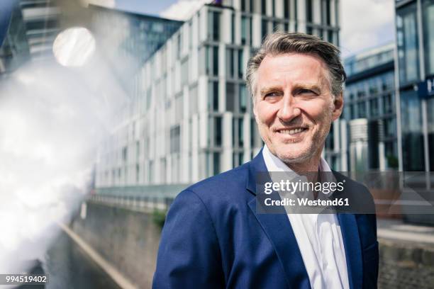 portrait of smiling mature businessman outdoors - looking away stock pictures, royalty-free photos & images