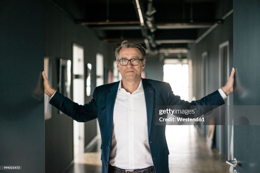 Portrait of mature businessman standing on office floor