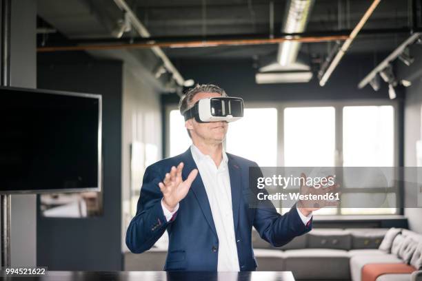 mature businessman wearing vr glasses - insight tv fotografías e imágenes de stock