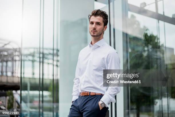 businessman leaning against glass facade - weißes hemd stock-fotos und bilder