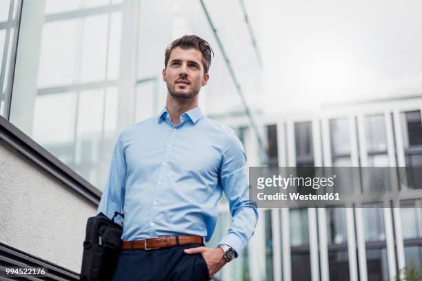 young businessman in the city outside office building - low angle view stock pictures, royalty-free photos & images