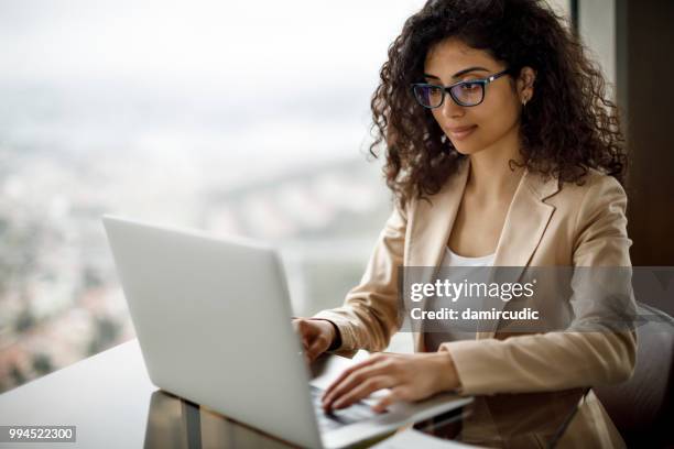 businesswoman working on laptop at a cafe - damircudic stock pictures, royalty-free photos & images