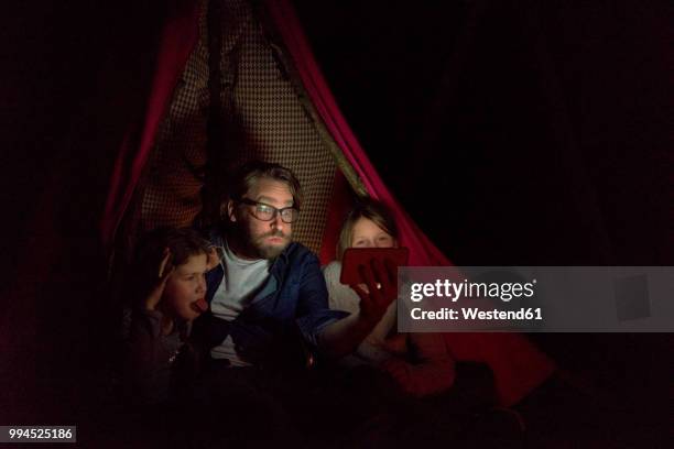 father and daughters sitting in tent, taking a selfie - the comedy tent stock pictures, royalty-free photos & images