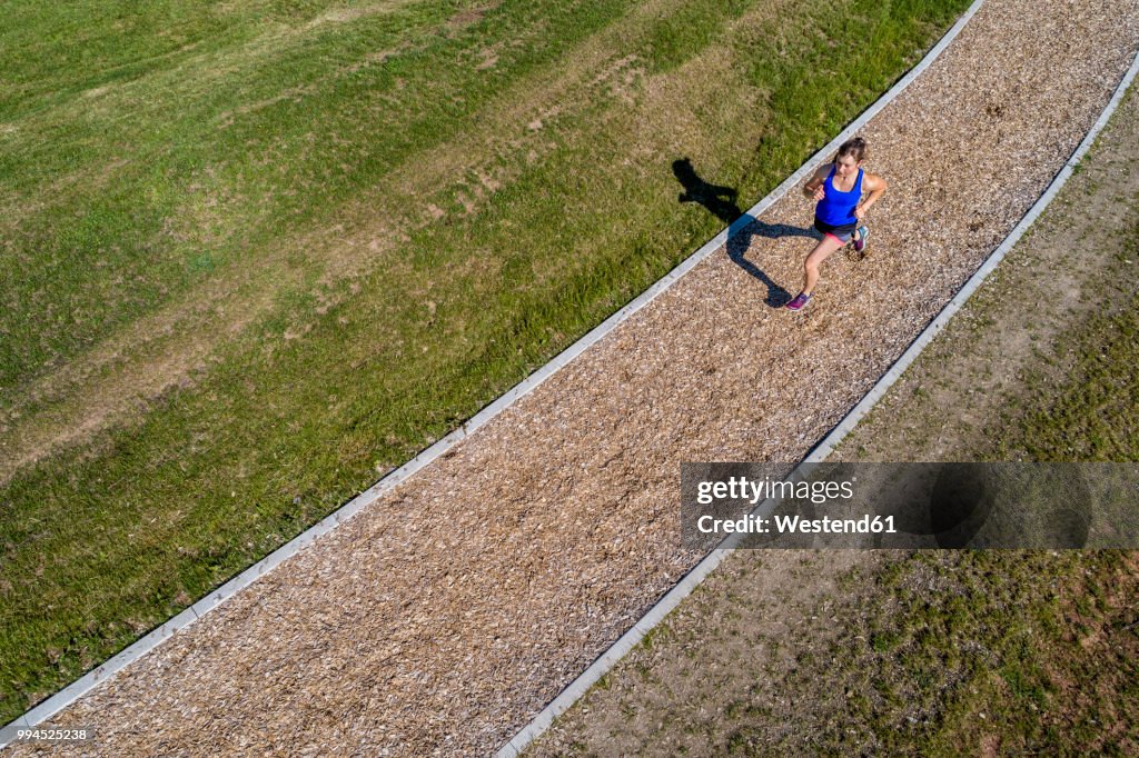 Aerial view of female jogger on woodchip trail