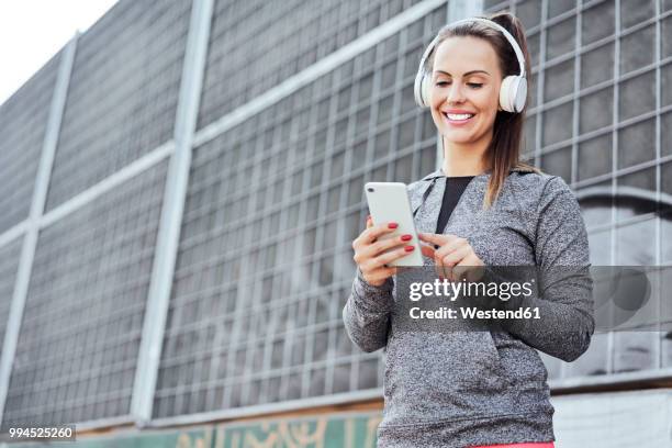 woman with headphones using smartphone - one katowice 2018 bildbanksfoton och bilder