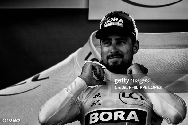 Slovakia's Peter Sagan, wearing the overall leader's yellow jersey, reacts on the podium after the second stage of the 105th edition of the Tour de...