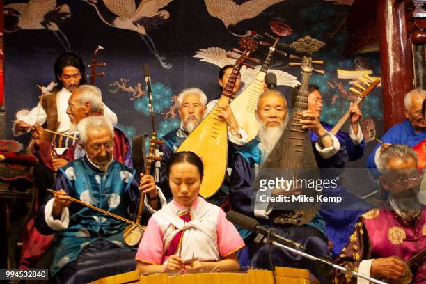 Elderly and young musicians in a Naxi Orchestra, a Naxi minority group playing at the Naxi Music Academy, Naxi Guyue Hui, in Old Town Lijiang, Yunnan...