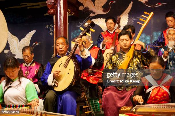 Elderly and young musicians in a Naxi Orchestra, a Naxi minority group playing at the Naxi Music Academy, Naxi Guyue Hui, in Old Town Lijiang, Yunnan...