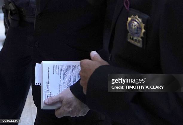 Harvey Weinstein arrives carrying a book at Manhattan Criminal Court July 9, 2018 in New York, for arraignment on charges alleging he committed a sex...