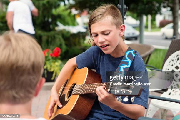 young guitar player rehearsing before show in family driveway. - "martine doucet" or martinedoucet stock pictures, royalty-free photos & images