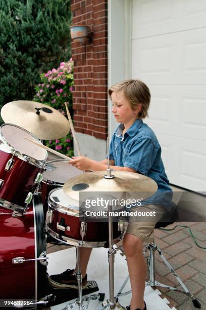 young drummer rehearsing before show in family driveway. - "martine doucet" or martinedoucet stock pictures, royalty-free photos & images