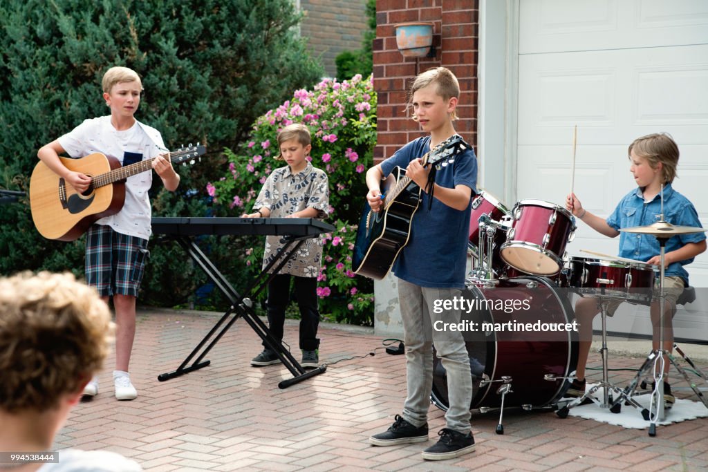 Boy's band in concert in family driveway in summer.
