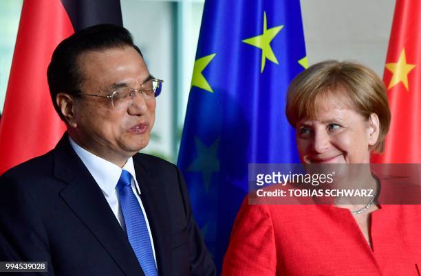 German Chancellor Angela Merkel and Chinese Premier Li Keqiang react prior a signing ceremony at the Chancellery in Berlin on July 9 as part of...