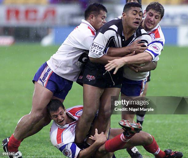 Ali Lauitiiti of New Zealand is wrapped up by Artie Shead Renaud Guigue and Frederic Banquet of France during the Rugby League Test Match between New...