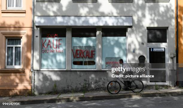 June 2018, Germany, Gera: Two signs in a show window read 'Zum Kauf' and 'verkaufen' at the Bauvereinstrasse. Photo: Jens Kalaene/dpa-Zentralbild/dpa