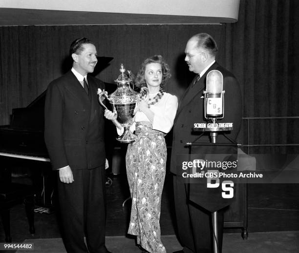 Actress Bette Davis is awarded the silver trophy of Redbook Magazine's Motion Picture Award for 1939. She receives the award for her performance in...