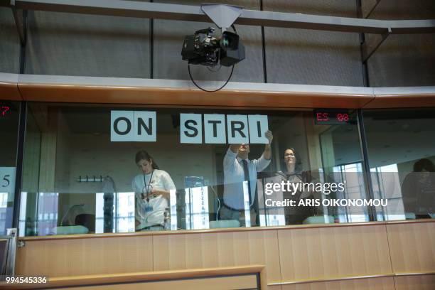 Interpreters at the European Parliament stick "On strike" banners on the windows of the their booths after 35 days of strike before the arrival of...