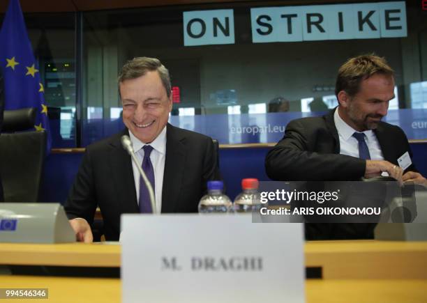 European Central Bank President Mario Draghi laughs before delivering speech during a meeting of the Committee on economic and monetary affairs in...