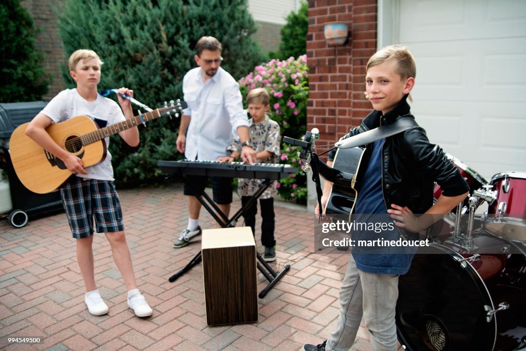 Boy's band getting ready to play in family driveway.