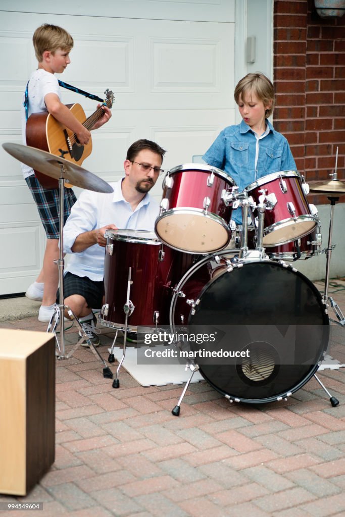 Boy's band getting ready to play in family driveway.