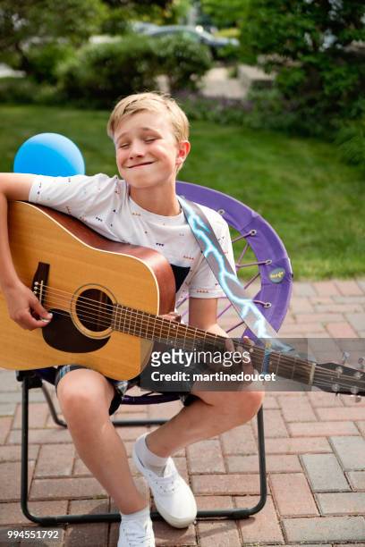 young guitar player rehearsing before show in family driveway. - "martine doucet" or martinedoucet stock pictures, royalty-free photos & images