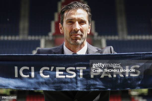 Italian goalkeeper Gianluigi Buffon poses with his new club's scarf on July 9, 2018 at the Parc des Princes stadium in Paris, after French Ligue 1...