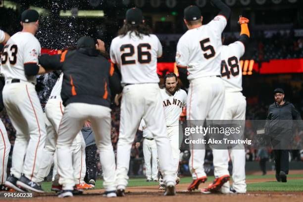 Brandon Crawford of the San Francisco Giants celebrates with his teammates after hitting a walk-off home run in the ninth inning to defeat the...