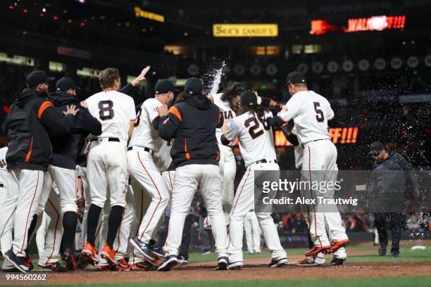 Brandon Crawford of the San Francisco Giants celebrates with his teammates after hitting a walk-off home run in the ninth inning to defeat the...
