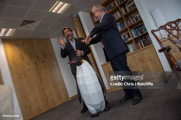 Oscar-winning actor Javier Bardem speaks with the Environment Secretary Michael Gove next to a cardboard penguin prvided by Greenpeace in his...