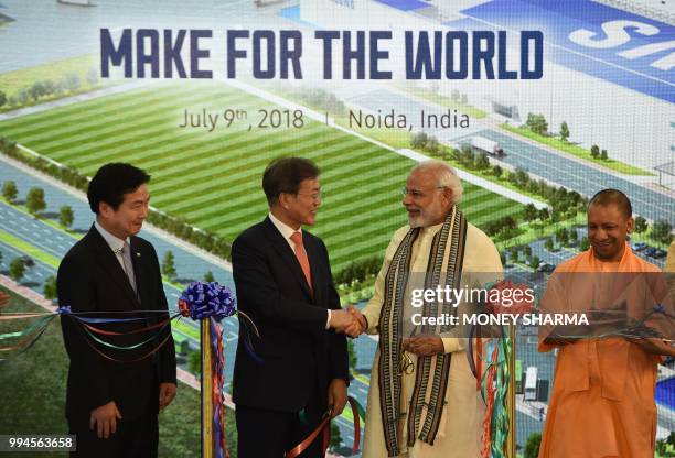 South Korea's President Moon Jae-in shakes hands with India's Prime Minister Narendra Modi as Chief Minister of Uttar Pradesh state Yogi Adityanath...