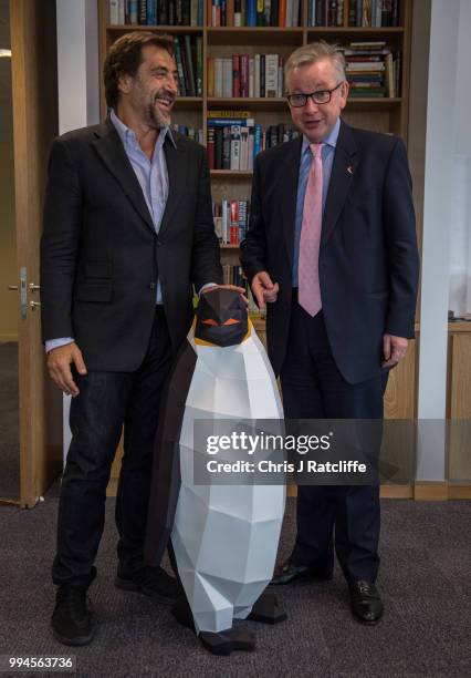 Oscar-winning actor Javier Bardem speaks with the Environment Secretary Michael Gove next to a cardboard penguin prvided by Greenpeace in his...