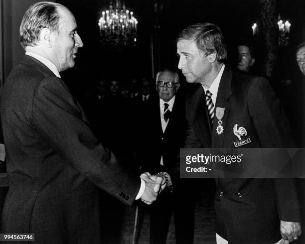 French President François Mitterrand shakes hands with Michel Hidalgo, coach of the French national team, after he was awarded Chevalier of the...