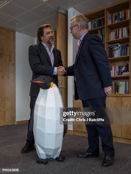 Oscar-winning actor Javier Bardem speaks with the Environment Secretary Michael Gove next to a cardboard penguin prvided by Greenpeace in his...