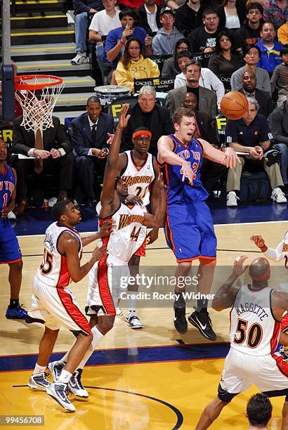 David Lee of the New York Knicks passes against Anthony Tolliver, Reggie Williams and Corey Maggette of the Golden State Warriors during the game at...