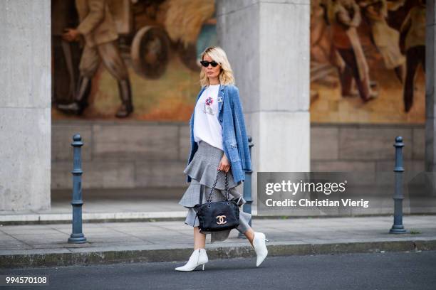 Gitta Banko wearing a denim-tweed blazer by Air Field, white t-shirt with hand painted Chanel brooch motive by Wodka Ogurez, grey checked asymmetric...