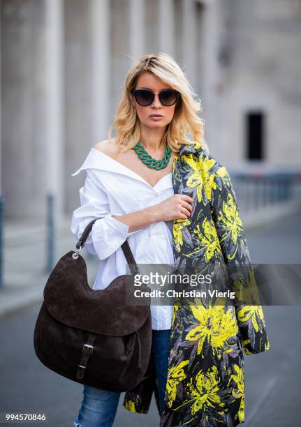 Gitta Banko wearing a floral patterned coat by Steffen Schraut, white off-shoulder blouse with asymmetrical cut by Balossa, brown suede bag by Amma...
