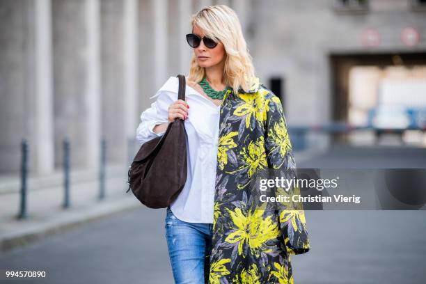 Gitta Banko wearing a floral patterned coat by Steffen Schraut, white off-shoulder blouse with asymmetrical cut by Balossa, brown suede bag by Amma...