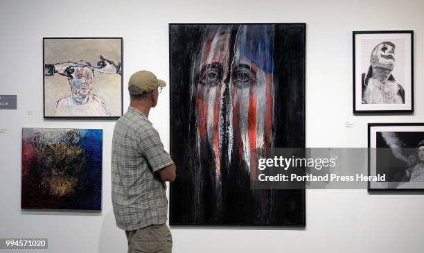Dave Hall of Raymond looks over the piece America Now by Leonard Meiselman at the America Now Exhibit Friday, July 6, 2018.