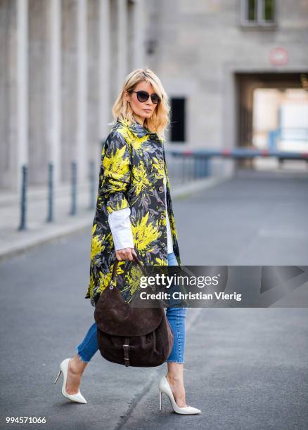 Gitta Banko wearing a floral patterned coat by Steffen Schraut, white off-shoulder blouse with asymmetrical cut by Balossa, brown suede bag by Amma...