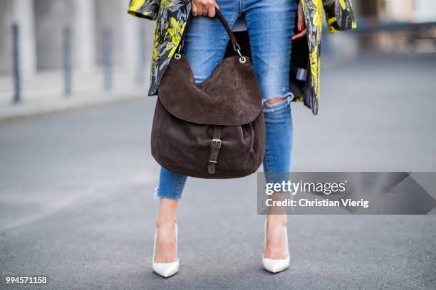 Gitta Banko wearing a floral patterned coat by Steffen Schraut, white off-shoulder blouse with asymmetrical cut by Balossa, brown suede bag by Amma...