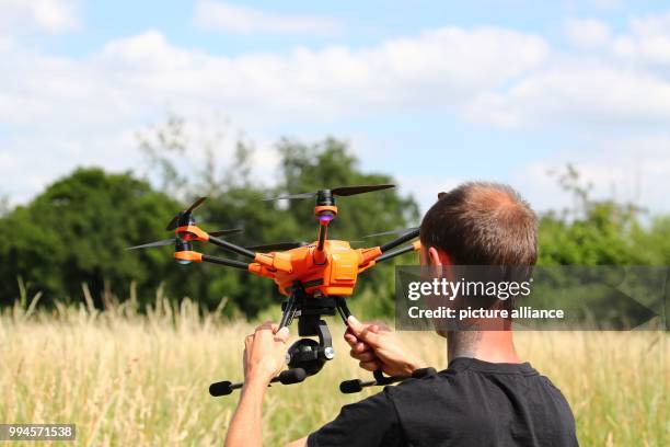 June 2018, Germany, Gera: Animal rights' activist Andreas Nowack holds a drone before its flight at the edge of a field. A project was initiated in...