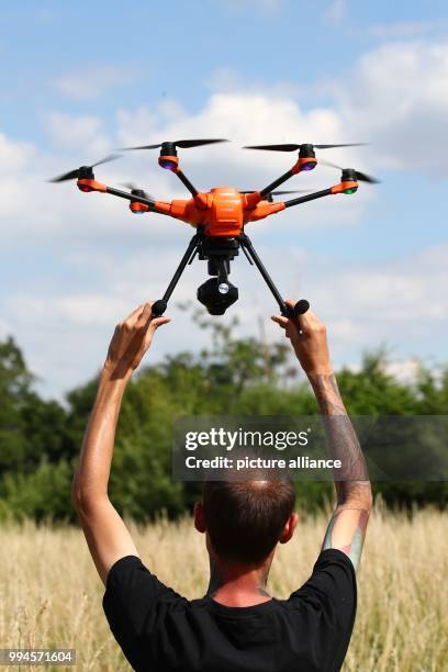 June 2018, Germany, Gera: Animal rights' activist Andreas Nowack holds a drone before its flight at the edge of a field. A project was initiated in...