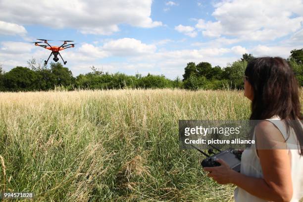 June 2018, Germany, Gera: Animal rights activist Dagmar Seidenbecher holds a drone before its flight at the edge of a field. A project was initiated...