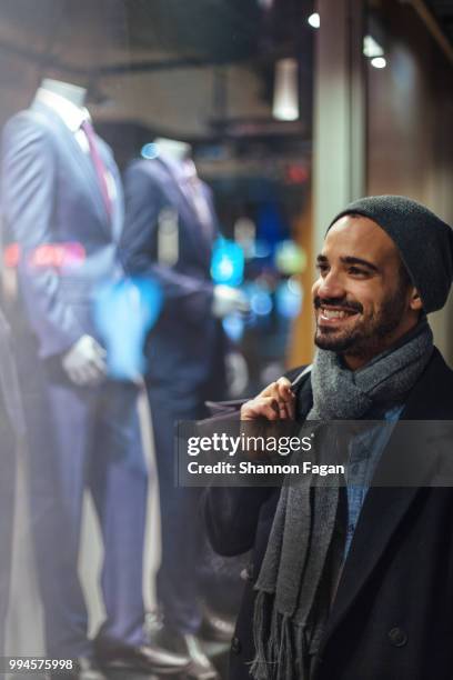 couple window shopping outdoors in winter - etalages kijken stockfoto's en -beelden