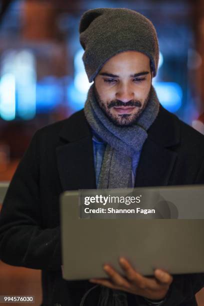 young man using laptop on city street at night - computer 2000 stock-fotos und bilder