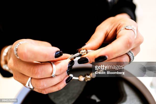 Store assistant handles a charm bracelet at a Pandora AS store in Copenhagen, Denmark, on Monday, July 9, 2018. Pandora designs, manufactures,...