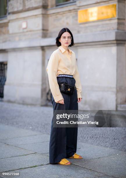 Maria Barteczko wearing light yellow silk blouse The Row, grey logo wide leg trousers Celine, yellow buckle slipper Mango, black leather belt bag...