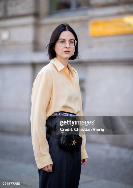 Maria Barteczko wearing light yellow silk blouse The Row, grey logo wide leg trousers Celine, yellow buckle slipper Mango, black leather belt bag...