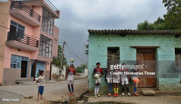 Members of the M2M football club pose for a photo at Ghamroj Village on June 27, 2018 near Gurugram, India. Once a cricket crazy village near...