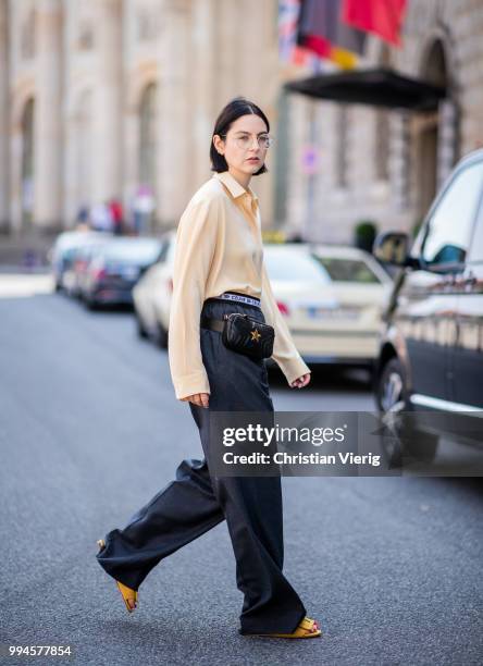 Maria Barteczko wearing light yellow silk blouse The Row, grey logo wide leg trousers Celine, yellow buckle slipper Mango, black leather belt bag...